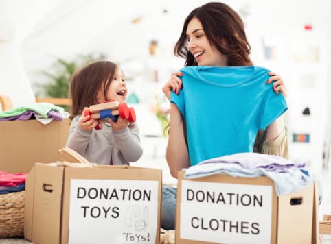 A mom and daughter donating clothes and toys
