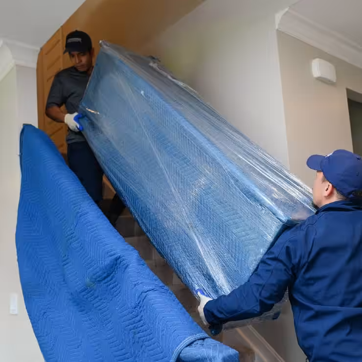 A Leaders team moving a wrapped piece of furniture to the truck.
