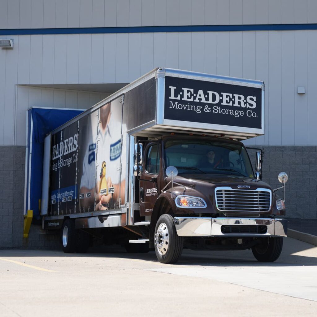 A Leaders Moving & Storage Co. truck parked at a loading dock