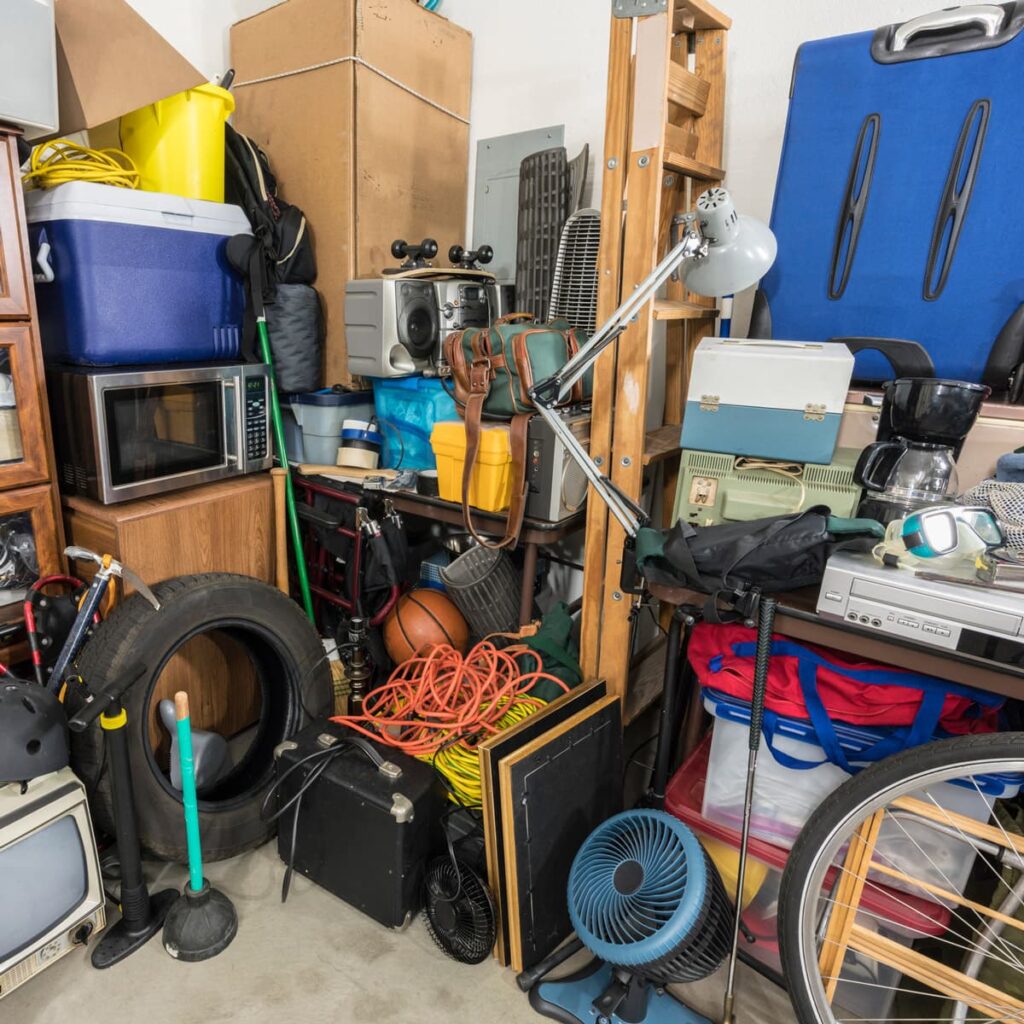 A cluttered corner of a garage with various junk items