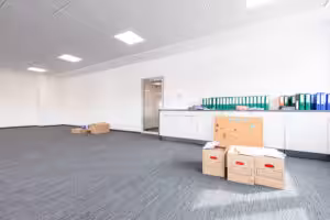 Packed moving boxes and binders in an office during a move, following an office moving checklist for an efficient transition.